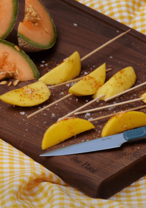 blue salt paring knife on cutting board with fruit