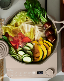 Assorted vegetables in a pan on a digital kitchen scale