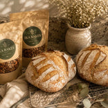Two loaves of sourdough bread next to two pouches of Ika Bakes granola.