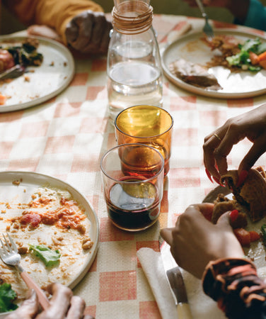 A dinner table with four people eating off Main Plates