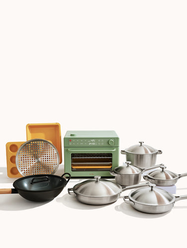 Set of stainless steel cookware including pots, pans, and a wok on a white background.