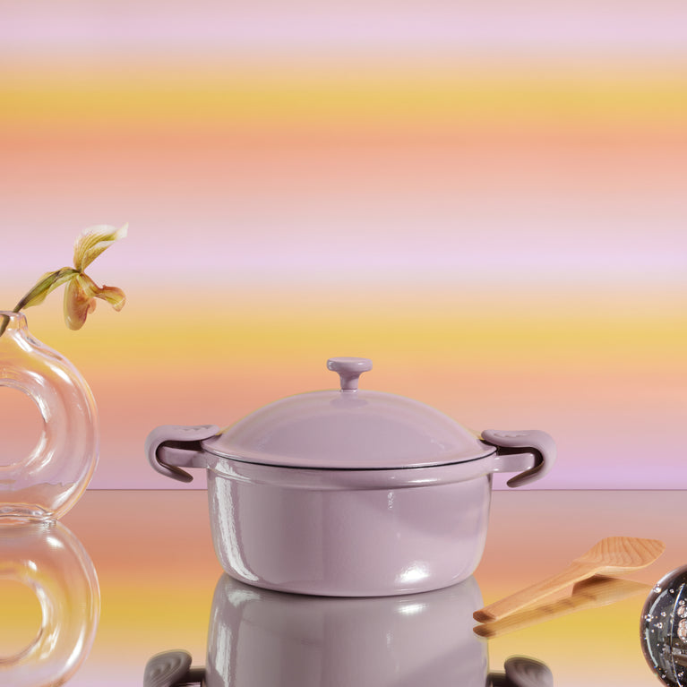 Purple Cast Iron Perfect Pot with scraper and hot grips on pink background