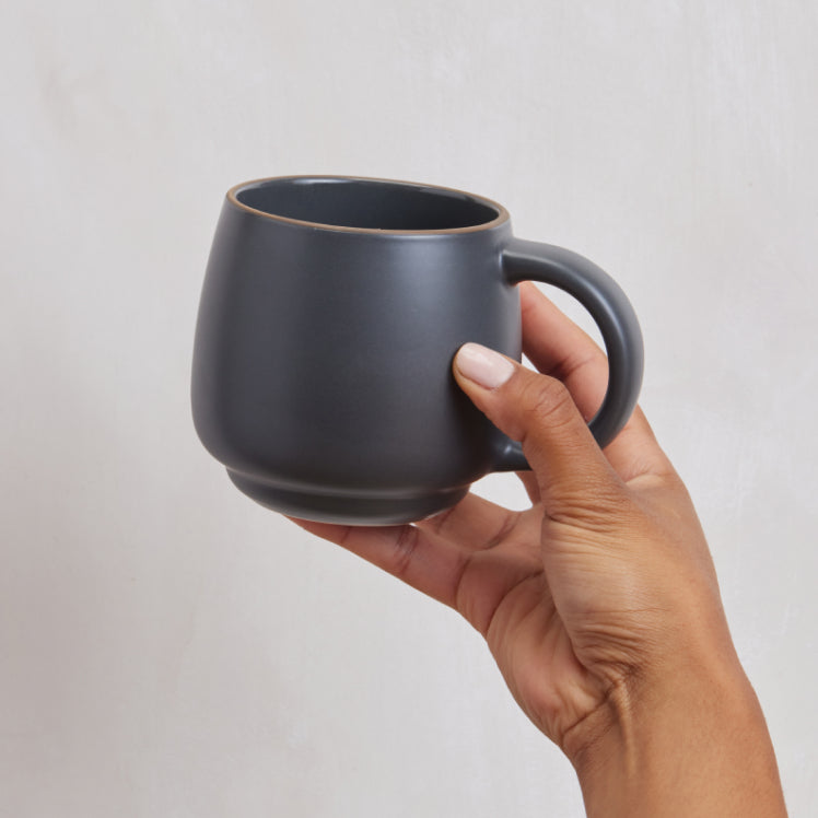 Handling a black Night + Day Mug