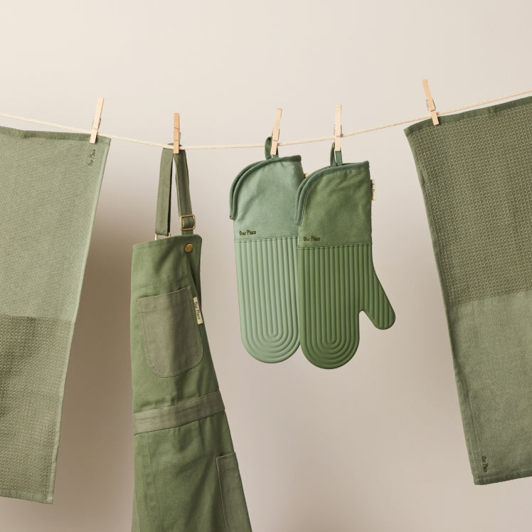 Green Home Cook Apron, Hot Mitts, and Double Dish Towels hanging from a clothesline