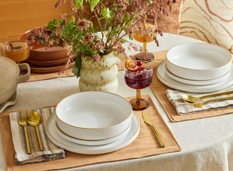 white dinner bowls, salad plates and dinner plates stacked on table