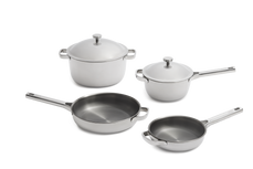 A set of four stainless steel pots and pans with lids.