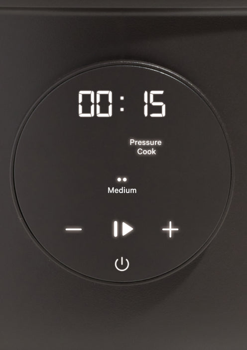 A digital pressure cooker control panel displays 00:15 minutes, set to “Pressure Cook” mode on “Medium.” The panel shows minus, plus, power, and start/pause touch buttons.