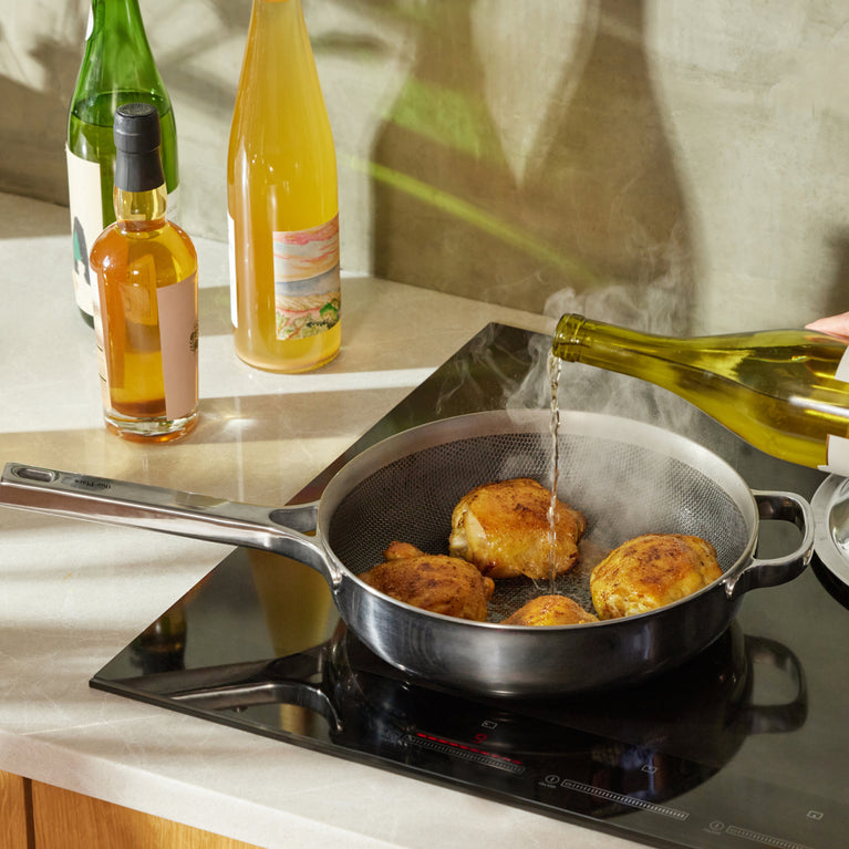 deglazing chrome titanium always pan pro with wine while cooking chicken on stove