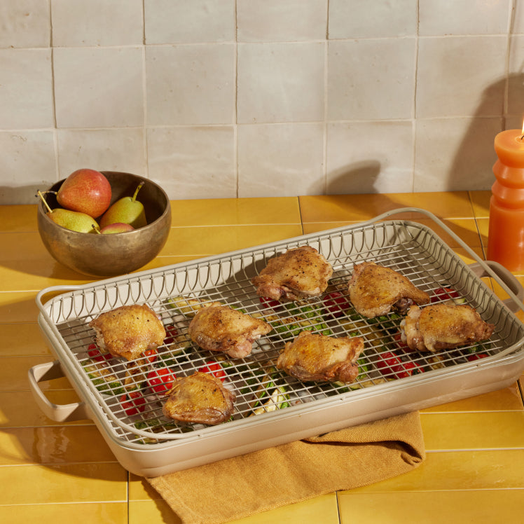 cooked chicken and vegetables on beige oven rack and griddle pan