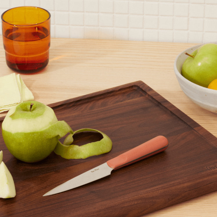 pink precise paring knife on walnut cutting board with apples