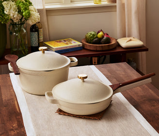 Set of cream ceramic cookware on a wooden countertop