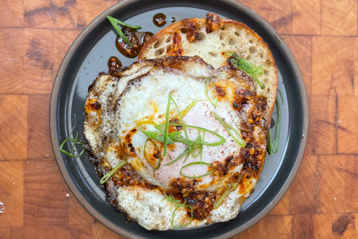 A fried egg cooking in a cast iron pan
