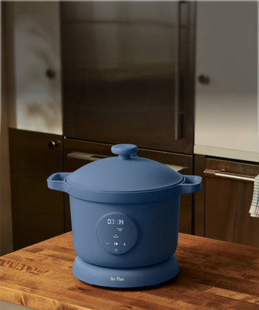 Blue rice cooker on a wooden countertop in a kitchen setting