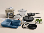 Set of cookware including pots, pans, and a small oven on a beige background