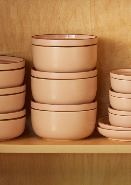 Pink tableware stacked on shelf