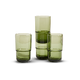 Four green glass tumblers of varying heights are arranged on a plain white background.