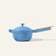 A light blue ceramic saucepan with a lid and a light wood handle, shown on a solid off-white background.