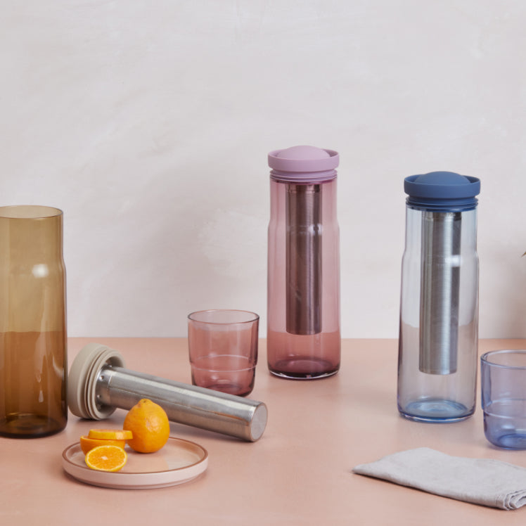 A set of beige, pink, and blue Night + Day Carafes on a table