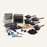 Set of black cookware and kitchen utensils on a white background