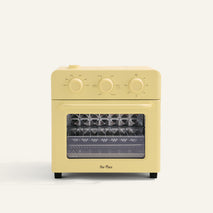 Yellow toaster oven with clear glass door on a white background