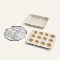 Set of three baking trays including a square pan, a muffin tray, and a pizza pan on a white background.