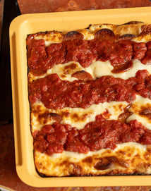 Rectangular pizza with pepperoni on a yellow tray