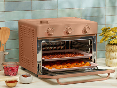 pink large wonder oven cooking vegetables on two trays