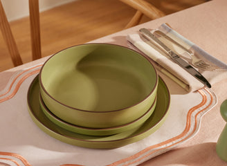 sage dinner bowls, salad plates and dinner plates stacked on table