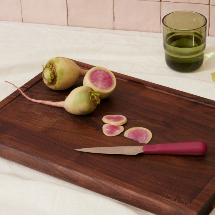 Red Precise Paring Knife on top of the Walnut Cutting Board with radish