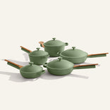 Set of green cookware with wooden handles on a white background