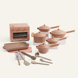 Set of pink cookware and kitchen appliances on a white background